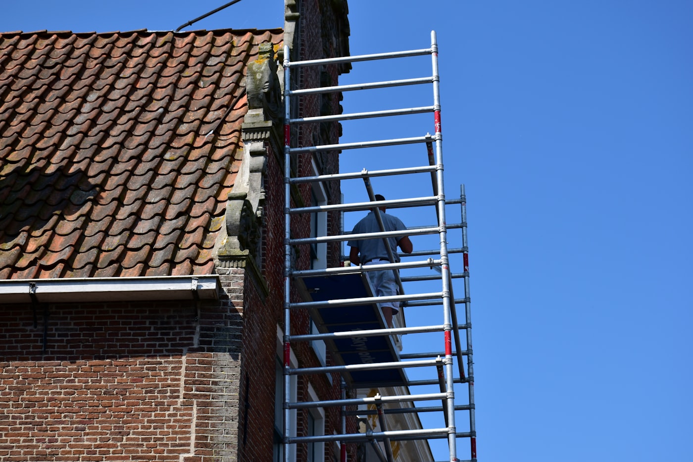 Scaffolding erected against a brick house for exterior renovation work