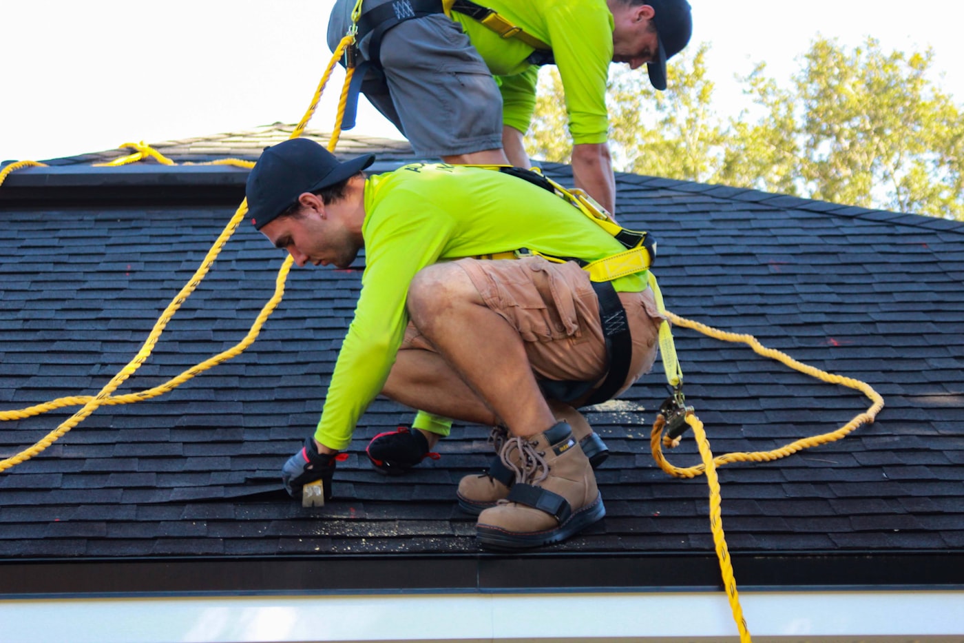 Two roofers repairing a pitched roof