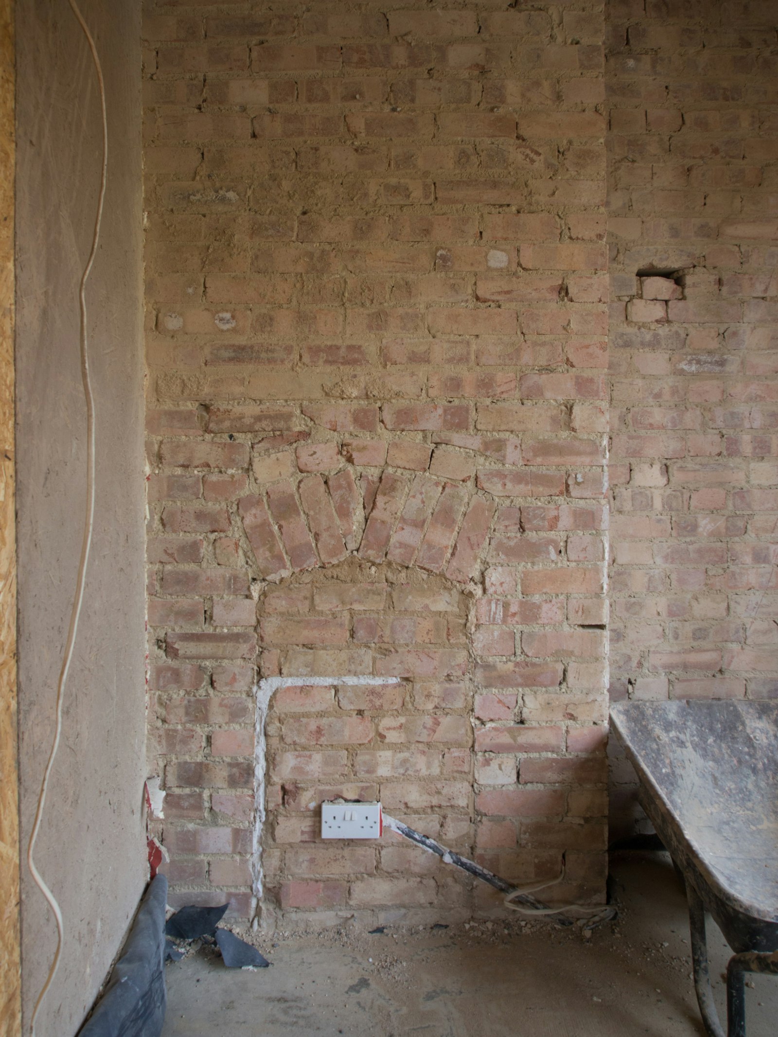 Interior stripped back to bare brick with old fireplace arch exposed