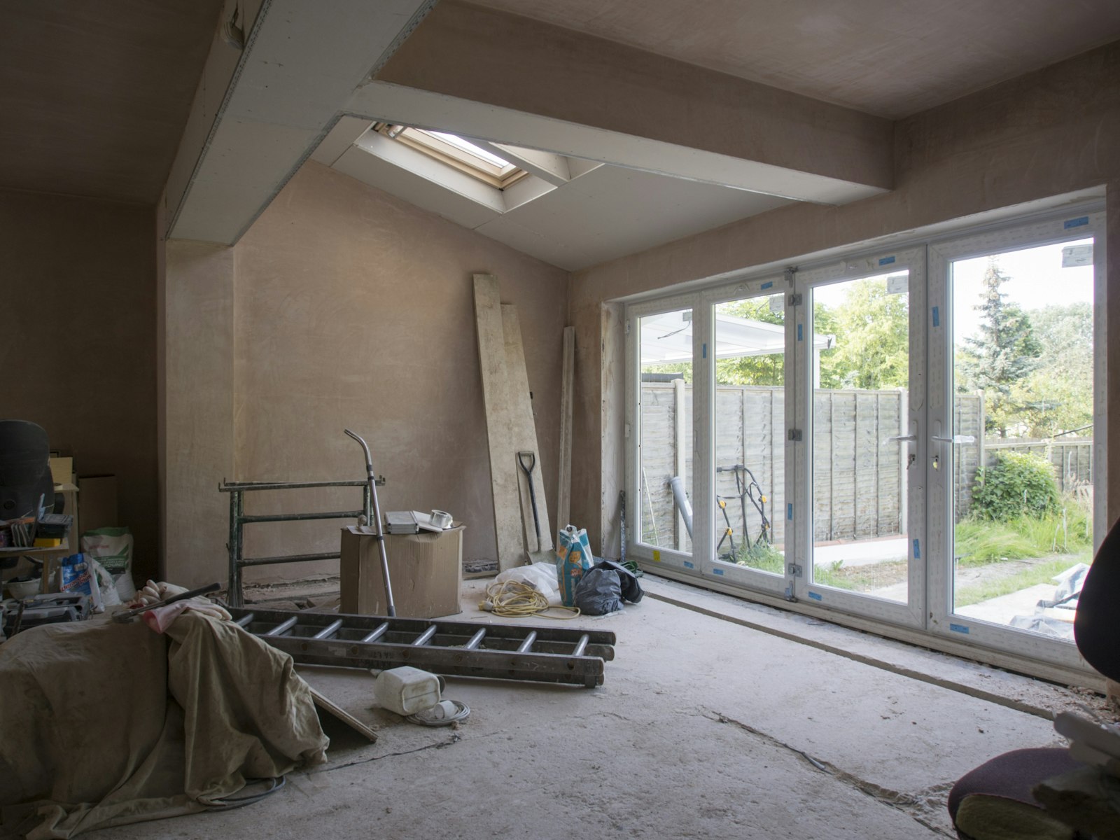 Replastered room with new bi-fold doors fitted, ready for finishing